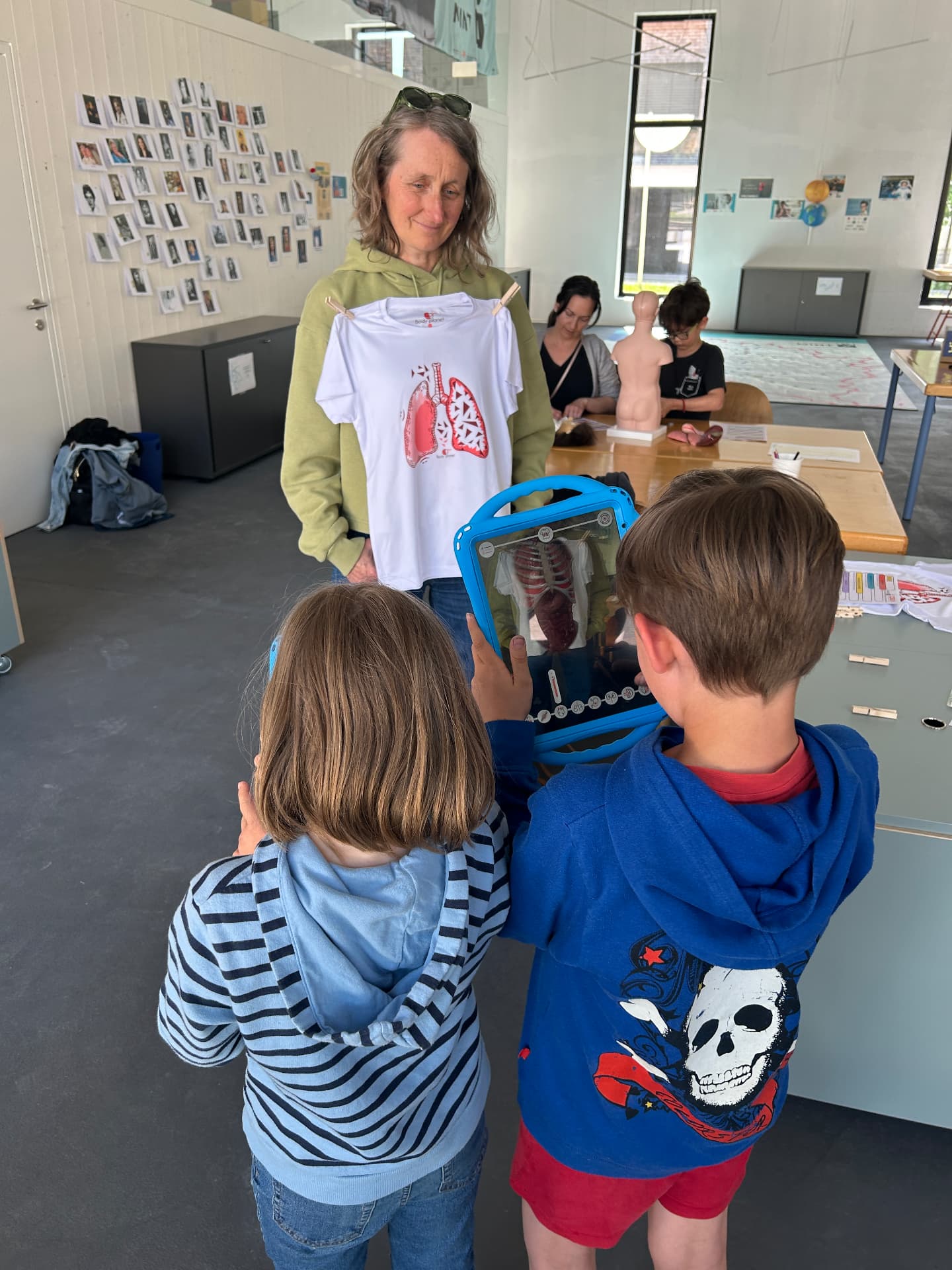 Kinder betrachten ein T-Shirt mit Lungen-Aufdruck